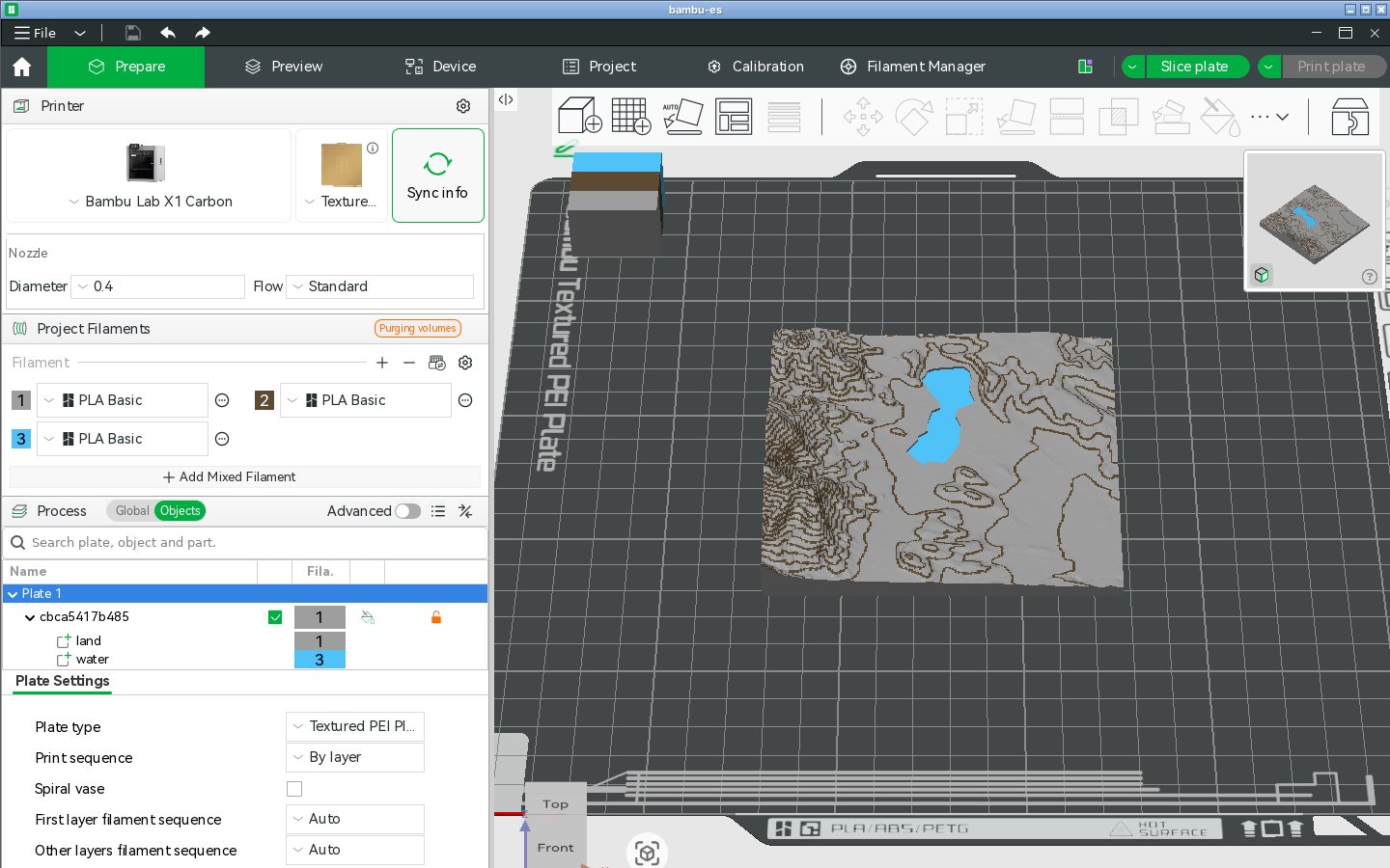 El 3MF de TrailMark3D del Lago de Banyoles abierto en la pestaña Preparar de Bambu Studio, en una Bambu Lab X1 Carbon, con tres filamentos del proyecto, el lago en azul y las curvas de nivel en marrón