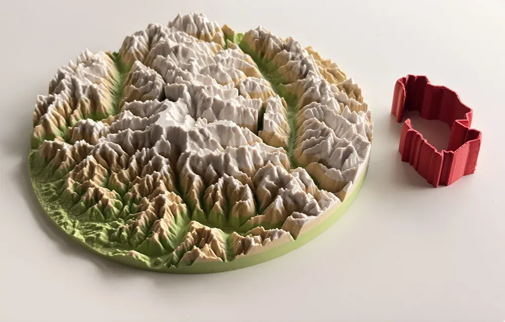 Un mapa real del Matterhorn impreso en 3D con TrailMark3D, con la ruta roja impresa como pieza aparte junto a la placa de terreno y su ranura