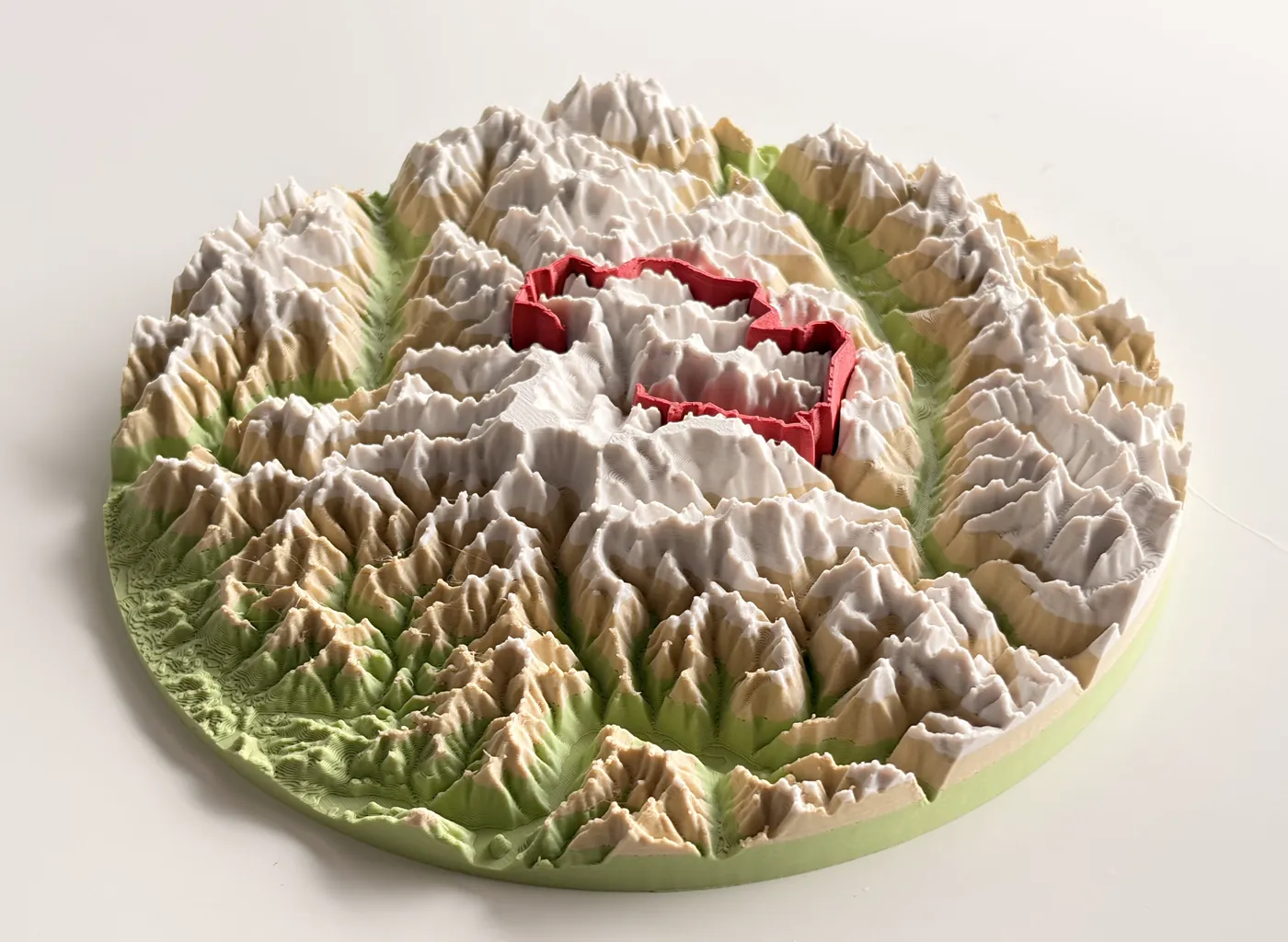 用 TrailMark3D 製作的瑞士阿爾卑斯山馬特洪峰多色實體 3D 列印地形圖:白色山峰、米色山坡、綠色山谷與凸起的紅色路線